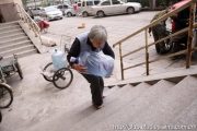 An old Chinese lady in her 70s delivers water in China to support her family.